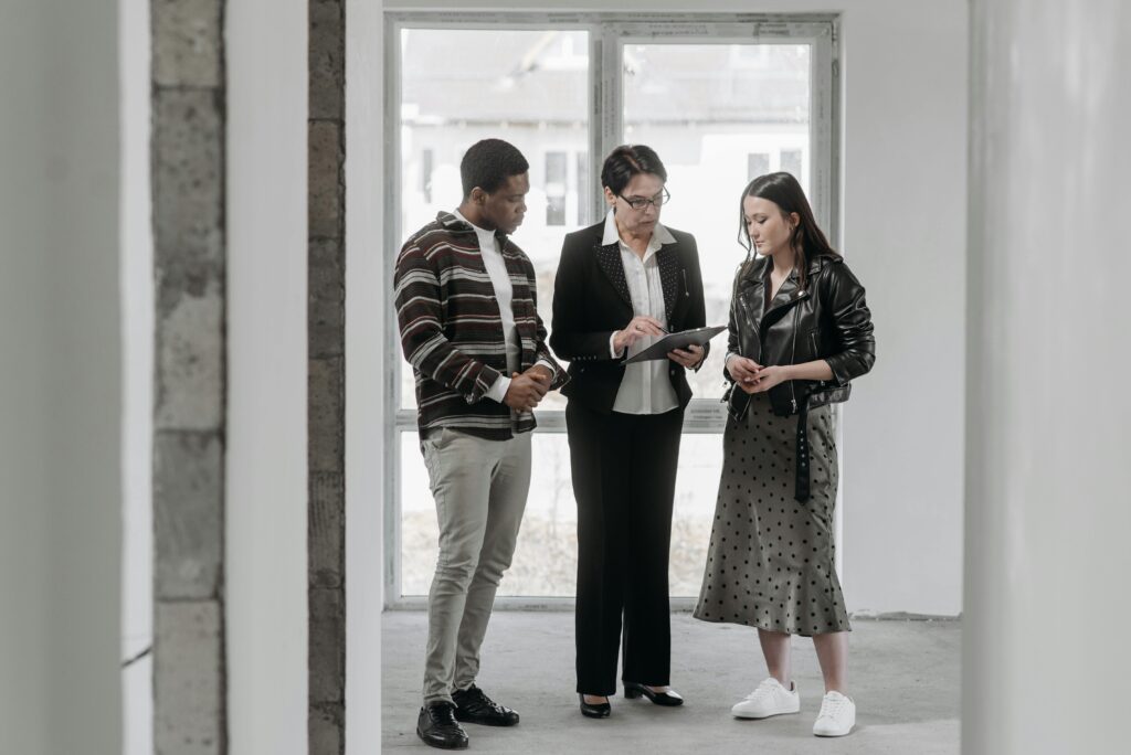 A real estate agent discusses property details with potential buyers during a house viewing.